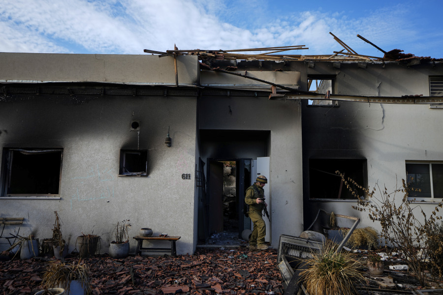 An Israeli soldier inspects a house damaged by Hamas militants in Kibbutz Be'eri, Israel, Tuesday, Oct. 17, 2023. The kibbutz was overrun by Hamas militants from the nearby Gaza Strip on Cot.7, when they killed and captured many Israelis.