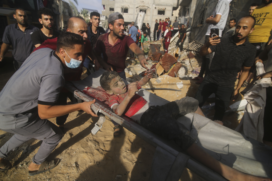 Palestinians pull a boy from the rubble after an Israeli strike on the Zaroub family house in Rafah, Gaza Strip, Tuesday, Oct.24, 2023.