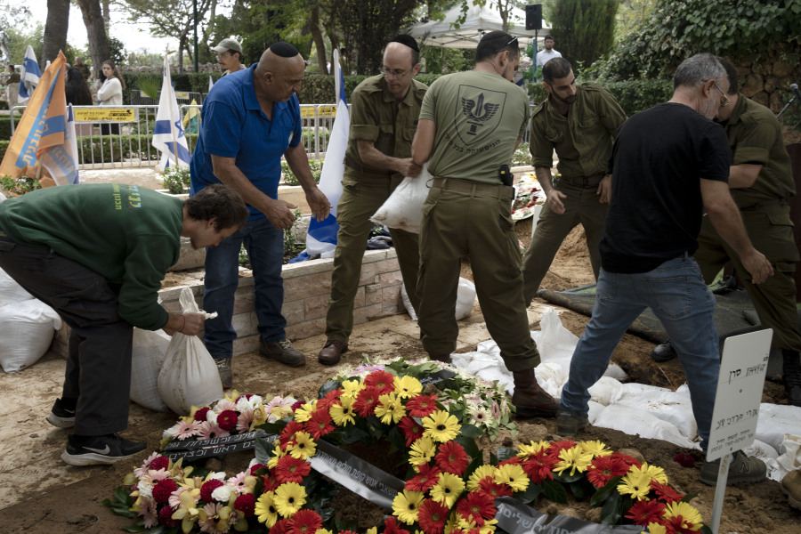 At Mt. Herzl military cemetery, grave diggers set up between funerals for Israeli soldiers killed in Saturday's surprise attack by Hamas militants on the Gaza border, in Jerusalem, Tuesday, Oct. 10, 2023.