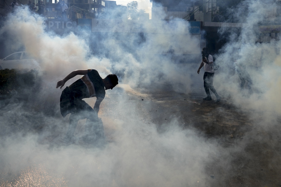 Riot police use tear gas against protesters during a demonstration, in solidarity with the Palestinian people in Gaza, near the U.S. embassy in Aukar, a northern suburb of Beirut, Lebanon, Wednesday, Oct. 18, 2023.