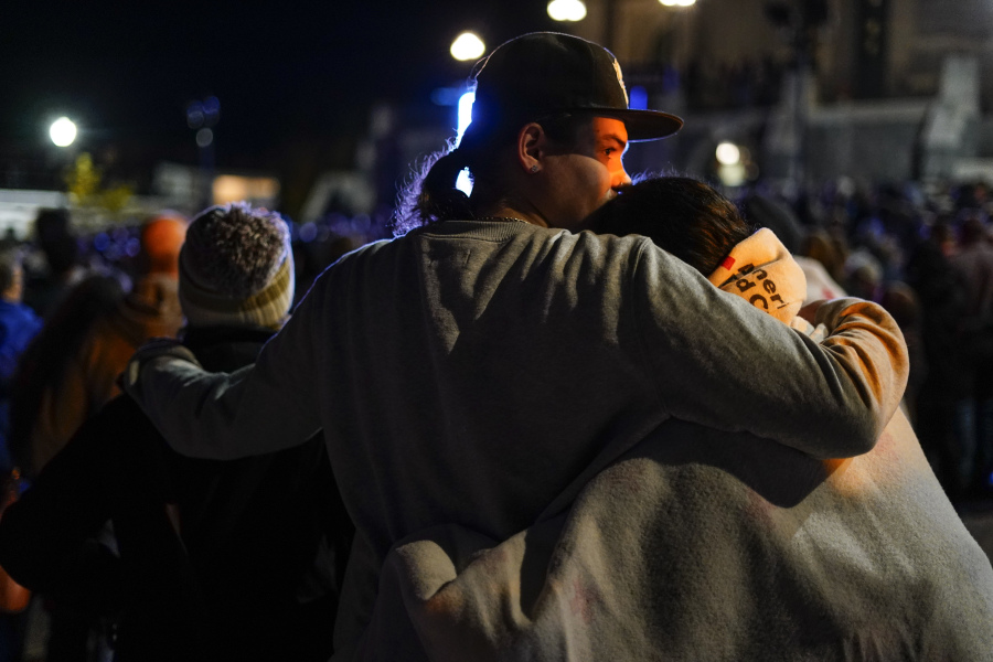 People linger after a vigil for the victims of Wednesday's mass shootings, Sunday, Oct. 29, 2023, outside the Basilica of Saints Peter and Paul in Lewiston, Maine.