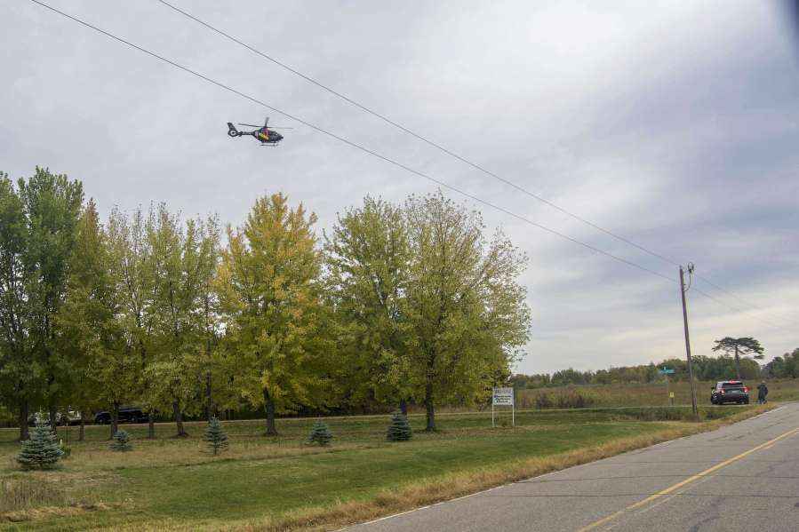 Law enforcement and helicopters are seen near where officers say has been a "critical incident" on Thursday, Oct. 12, 2023, near Princeton, Minn. Several law enforcement officers were shot and wounded Thursday morning, authorities said.