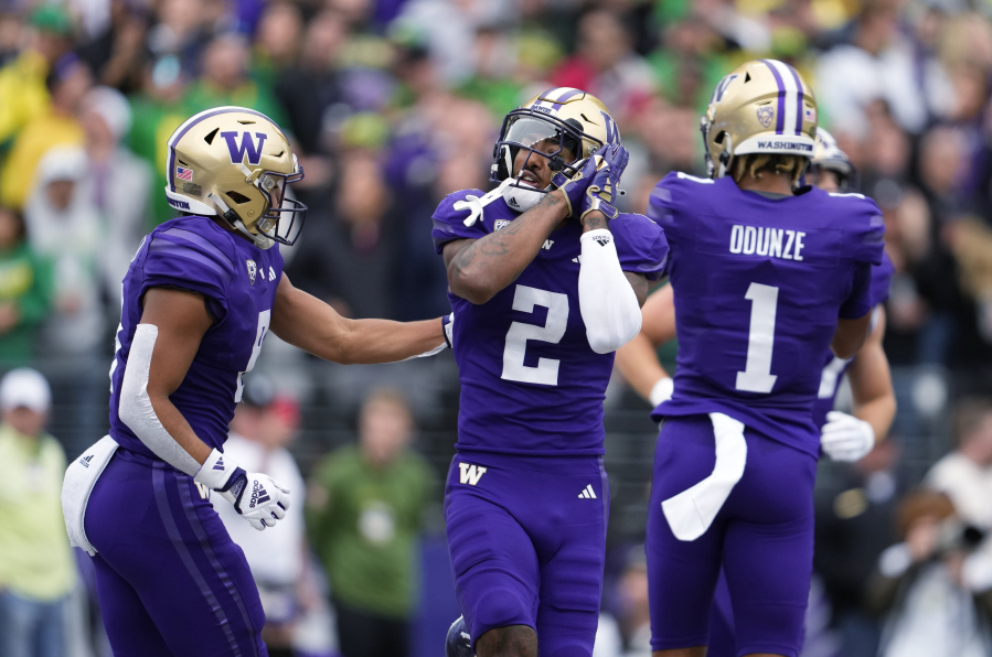 Washington wide receiver Ja'Lynn Polk (2) reacts with Will Nixon, left, after scoring a touchdown against Oregon during the first half of an NCAA college football game Saturday, Oct. 14, 2023, in Seattle.
