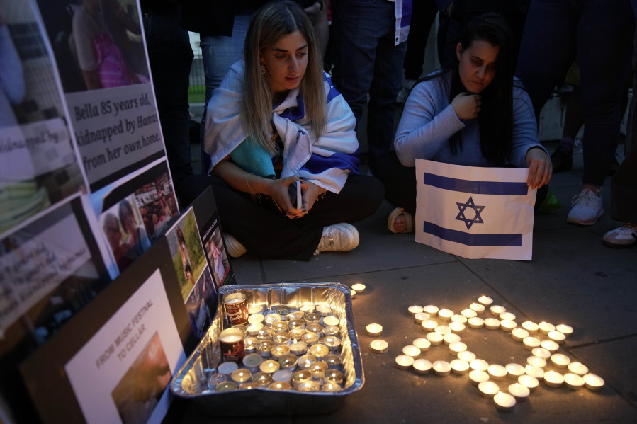 People light candles during the 'Jewish Community Vigil' for Israel in London, Monday, Oct. 9, 2023 two days after Hamas fighters launched an unprecedented, multi-front attack on Israel which killed more than 700 people. The militants blew through a fortified border fence and gunned down civilians and soldiers in Israeli communities along the Gaza frontier during a Jewish holiday.