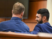Defendants Matthew Collins, left, and Christopher "Shane" Burbank talk in the gallery during the pre-trail motion in the trial of Tacoma Police Officers Christopher Burbank, Matthew Collins and Timothy Rankine in the killing of Manny Ellis at Pierce County Superior Court Monday, Sept. 18, 2023, Tacoma, Wash.