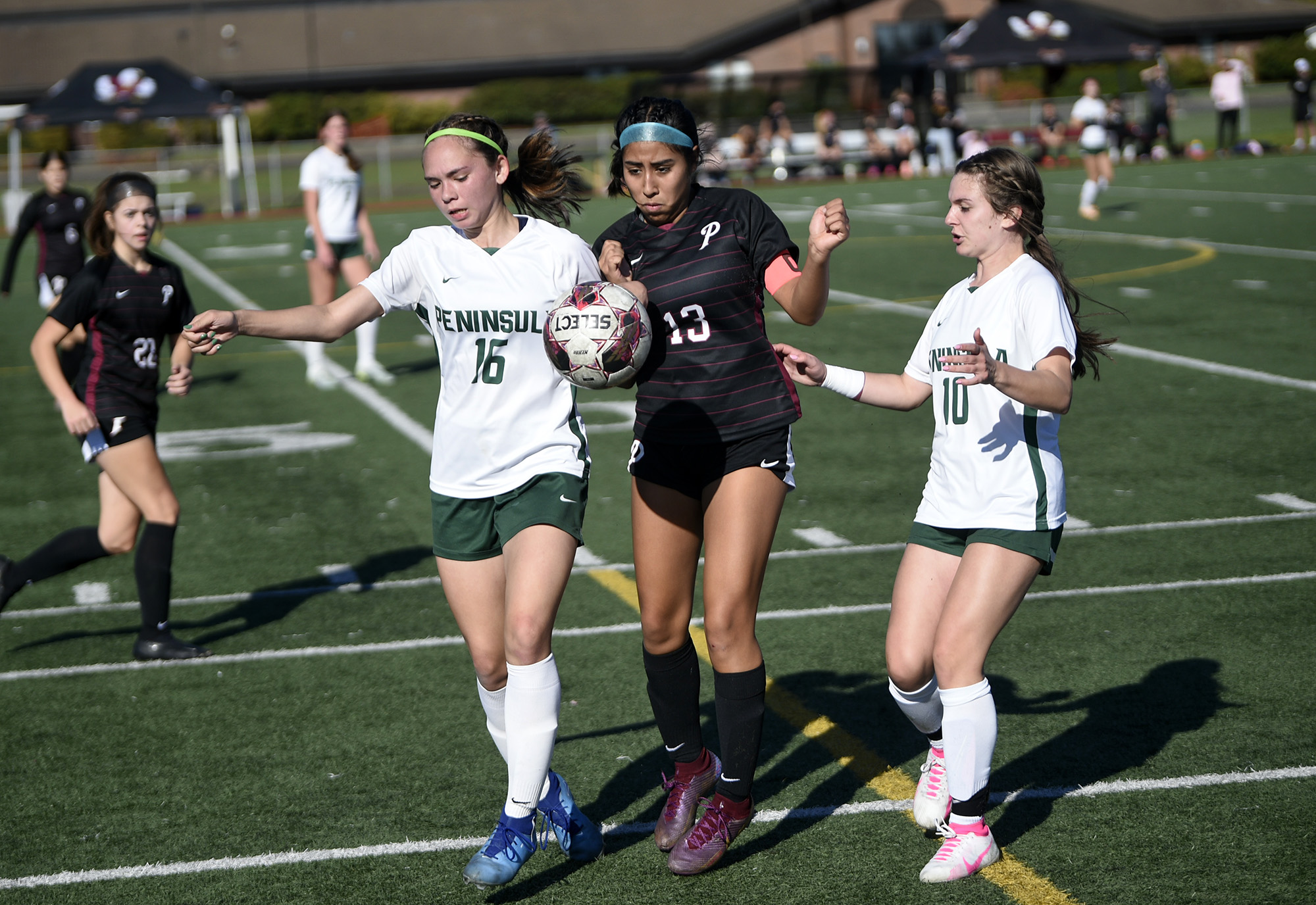 Mya Toguchi (13) of Prairie battles for possession of the ball with Peninsula's Maya Kalahiki (16) and Maya Rogers (10) uring the Falcons' 1-0 loss to Peninsula of Purdy in a Class 3A girls soccer bi-district playoff at Prairie High School on Saturday, Oct. 28, 2023.