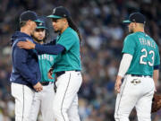 Seattle Mariners manager Scott Servais, left, pulls starting pitcher Luis Castillo from a baseball game against the Texas Rangers during the third inning, Saturday, Sept. 30, 2023, in Seattle.
