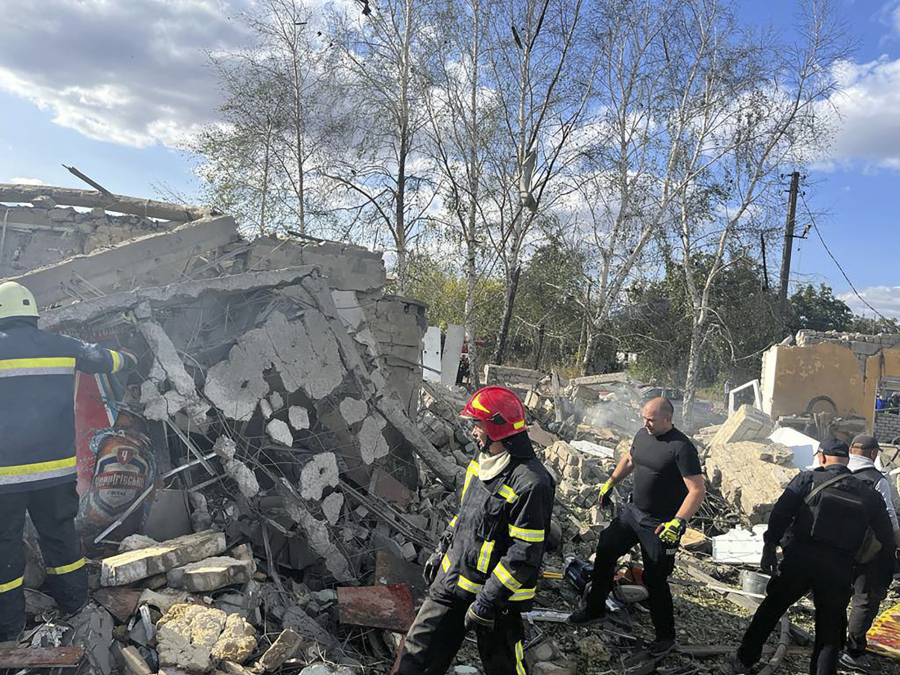 In this photo provided by the Ukrainian Presidential Press Office, emergency workers search the victims of the deadly Russian rocket attack that killed more than people in the village of Hroza near Kharkiv, Ukraine, Thursday, Oct. 5, 2023.