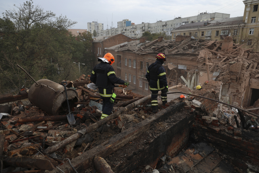 Emergency workers search for victims after a Russian air attack that damaged an apartment building in central Kharkiv, Friday, Oct. 6, 2023.