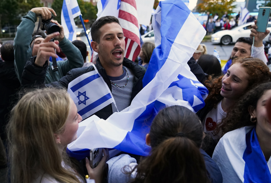 Demonstrators dance in a circle and wave Israeli flags during a rally in support of Israel, Monday, Oct. 9, 2023, in Bellevue, Wash.