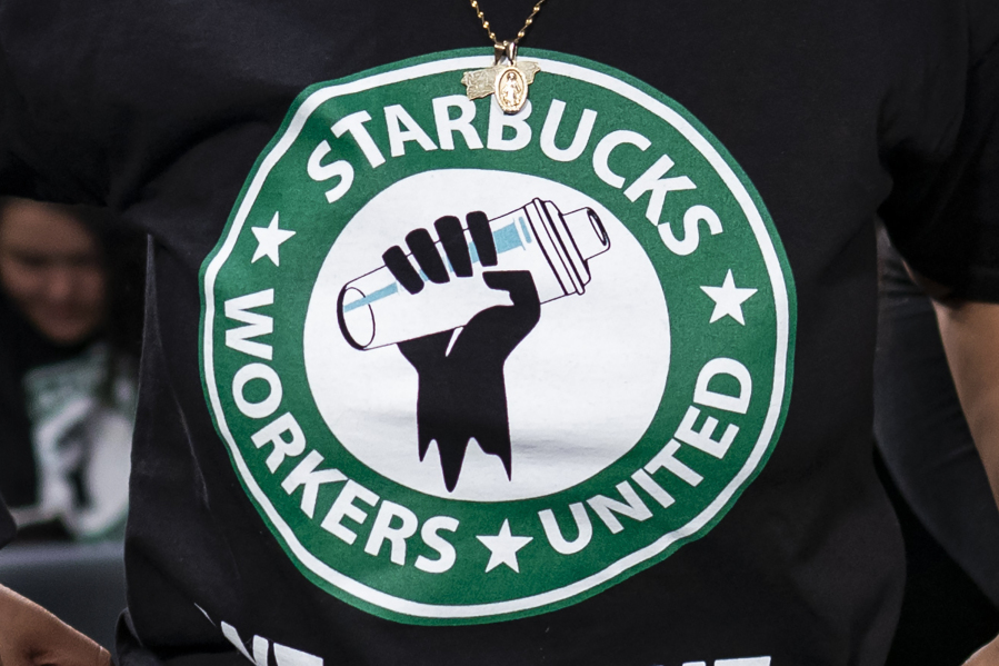 File - The Starbucks Workers United logo appears on the shirt of a person attending a hearing in Washington on March 29, 2023. Starbucks sued the union organizing its workers Wednesday, saying a pro-Palestine social media post from a union account early in the Israel-Hamas war angered hundreds of customers and damaged its reputation. (AP Photo/J.