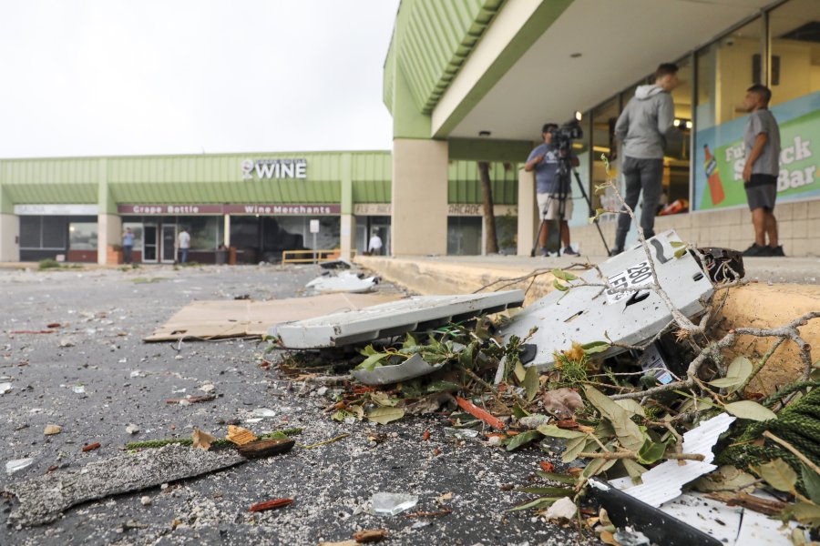 Debris remains in the parking lot outside of Bingo Time in Dunedin, Fla., on Thursday, Oct. 12, 2023. An early morning storm system that moved across parts of Florida left a path of damage to cars, houses and businesses.  (Douglas R.
