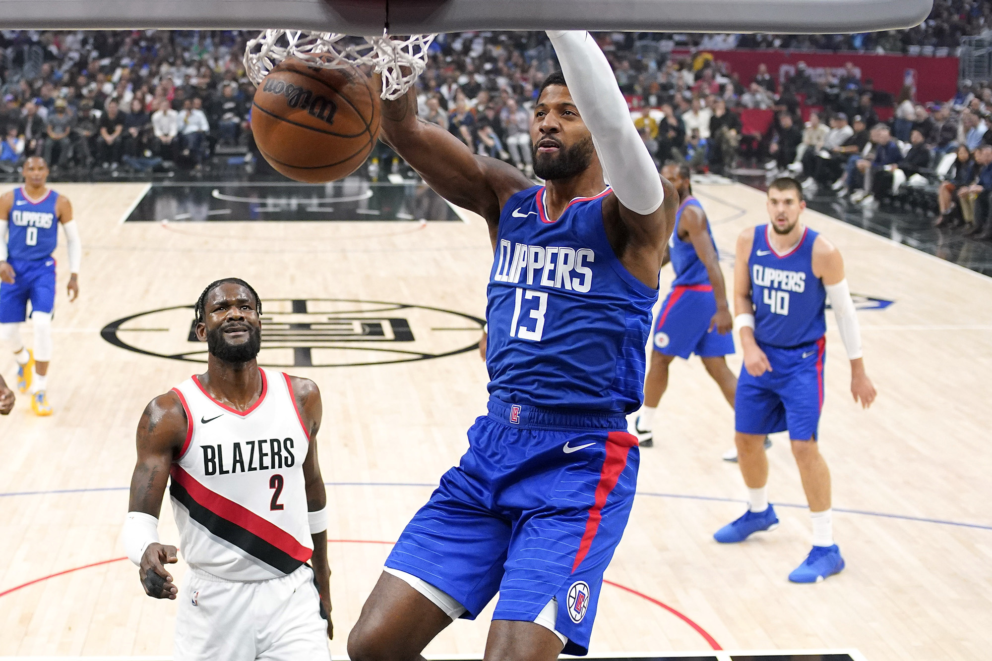 Los Angeles Clippers forward Paul George, center, dunks as Portland Trail Blazers Deandre Ayton, second from left, watches during the first half of an NBA basketball game Wednesday, Oct. 25, 2023, in Los Angeles. (AP Photo/Mark J.