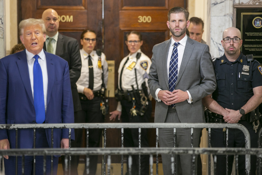 Eric Trump listens as his father, former president Donald Trump, speaks to the media in the hallway outside the New York City courtroom where his civil business fraud case is underway on Wednesday, October 25, 2023. Eric Trump, along with the former president's other son, Donald Trump Jr. and daughter Ivanka Trump, are expected to testify on the witness stand in the trial. Donald Trump is set to testify on November 6 in the case that threatens to disrupt their family's real estate empire.