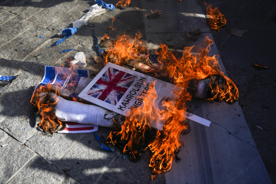 Protesters burn mocks of British, Israeli and American flags during a protest to show their solidarity with the Palestinians, in Istanbul, Turkey. Friday, Oct. 20, 2023.
