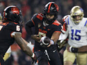 Oregon State quarterback DJ Uiagalelei (5) hands off the ball to running back Damien Martinez (6) during the second half of the team's NCAA college football game against UCLA on Saturday, Oct. 14, 2023, in Corvallis, Ore.