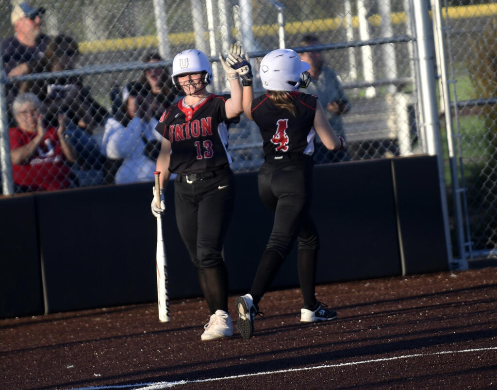 Union's Victoria Ross congratulates Addison Moe (4) after Moe scored in the Titans' 15-11 win over Skyview in the 4A district slowpitch softball championship game at Heritage High School on Thursday, Oct. 19, 2023.