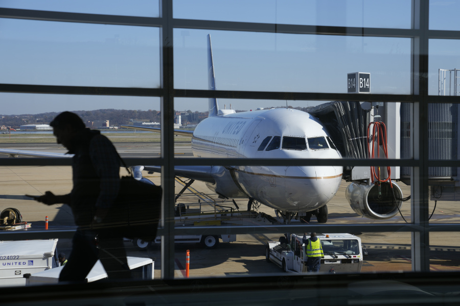 File - A United Airlines plane sits at a gate at Ronald Reagan Washington National Airport in Arlington, Va., Nov. 23, 2022. United Airlines says that it will start boarding passengers in economy class with window seats first starting next week, a move that will speed up boarding times for flights.