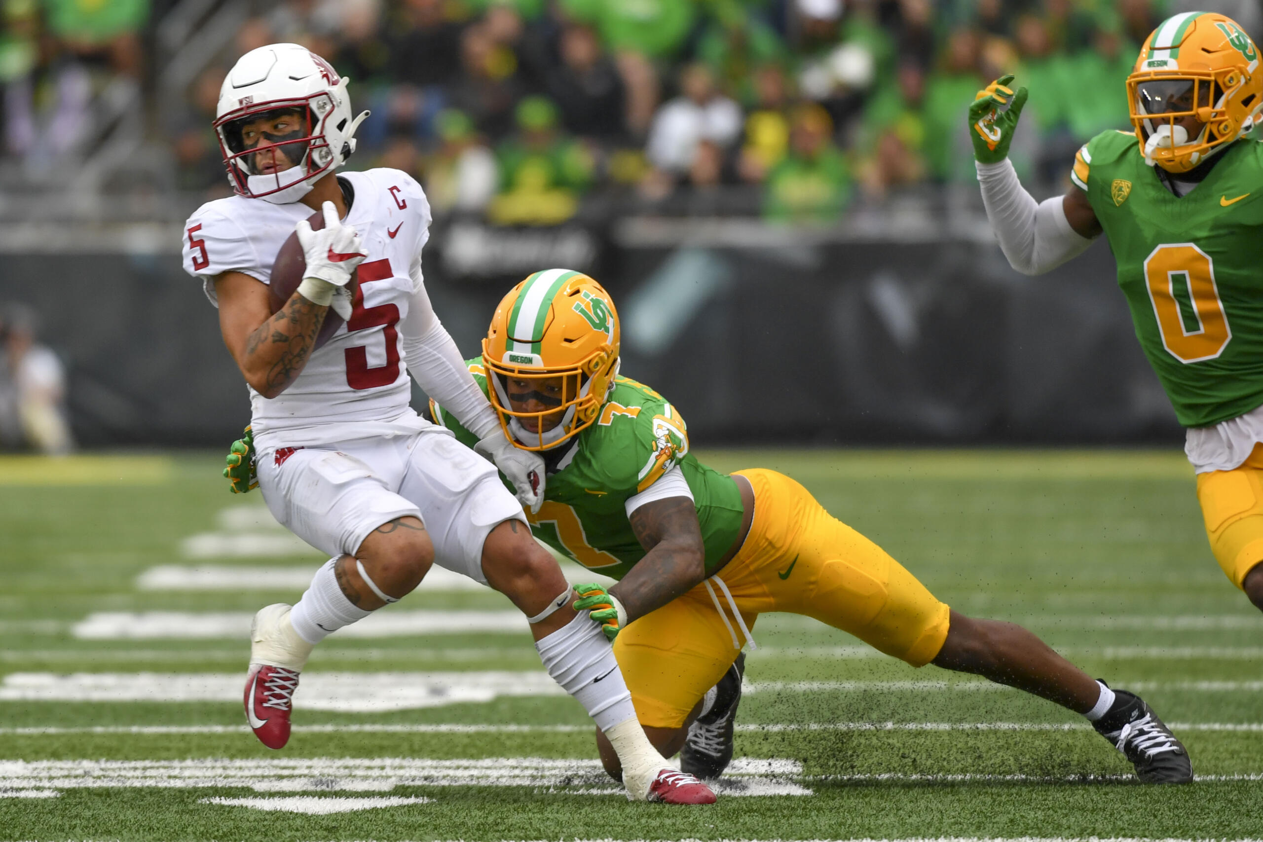 Washington State wide receiver Lincoln Victor (5) is tackled by Oregon defensive back Steve Stephens IV (7) during the second half of an NCAA college football game Saturday, Oct. 21, 2023, in Eugene, Ore.
