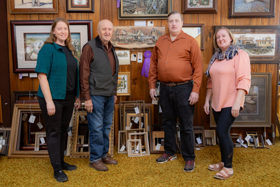 From the left: Gemé Art owners Jennifer Will, Gene Will, Nathan Will, and Stephanie Will stand in front of the store's collection of 3D art made with paper tole, a staple of the store's business.