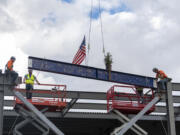 Workers move a beam into position Thursday during a "topping out" ceremony at Clark College's Boschma Farms campus in Ridgefield. The beam is the final piece of the structure of the school's new Advanced Manufacturing Center, which will be completed next year.