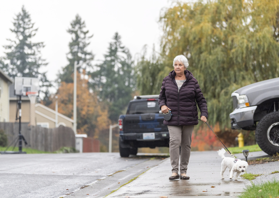 Darlene Schwieter walks her dog Scout, a 14-year-old bichon poodle, in her neighborhood in Ridgefield. Schwieter is one of nearly 100 people who have signed their pets up for the Clark County Sheriff&rsquo;s Office&rsquo;s Paws on Patrol program.