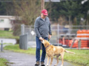 Jesse Peterson, left, walks with Charley, his 10-year-old yellow Labrador retriever, Nov. 15 in Ridgefield.