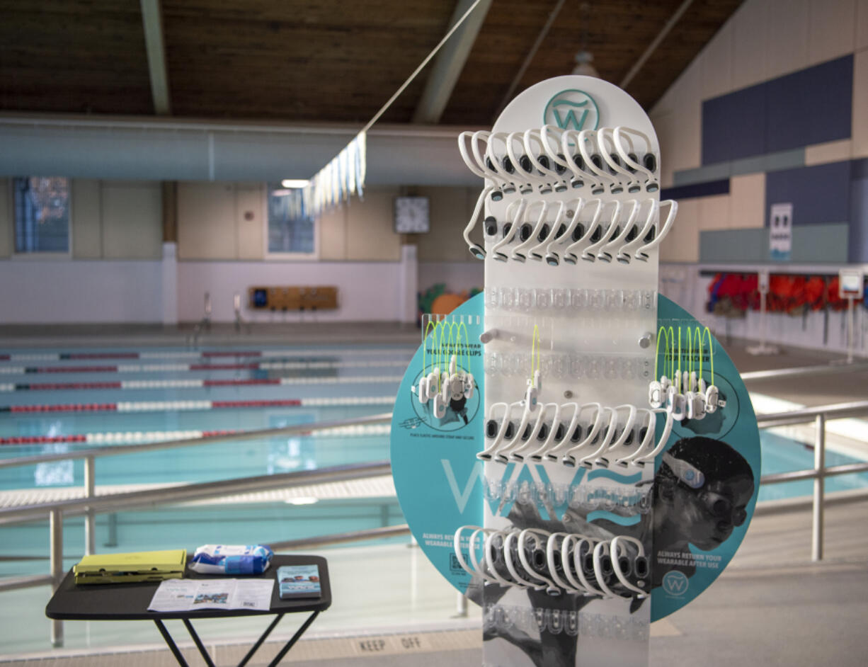 WAVE Drowning Detection headsets sit on a stand Tuesday at the Marshall Pool. Over the next month, swimmers will be asked to wear the headsets while swimming &mdash; the system alerts lifeguards to when swimmers remain submerged for too long.