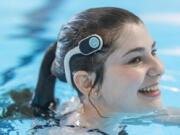 Lifeguard Kendall Lotka demonstrates how to wear a WAVE Drowning Detection headset while swimming Tuesday at the Marshall Pool. The city of Vancouver is testing the new technology over the next month to aid lifeguards in keeping pools safe.