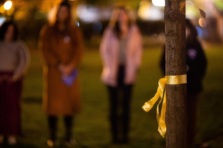 Members of the Transgender community, Vancouver police and allies wrap a ribbon around the tree planted for Nikki Kuhnhausen, a 17-year old transgender girl murdered in 2019.