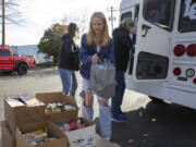 La Center Middle School student Chloe Daarud, 12, unloads donations from La Center's Stuff the Bus food drive at FISH of Vancouver. She said she got the idea to donate to FISH after donating her birthday money to the organization two years prior.