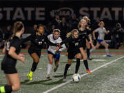 Klahowya junior Amira Lyons and Klahowya junior Kelsey Clark hold off La Center senior forward Madisen Newbury in a challenge for the ball in a 1A State girls soccer semifinal game on Friday, Nov. 17, 2023, at Mount Tahoma Stadium in Tacoma.