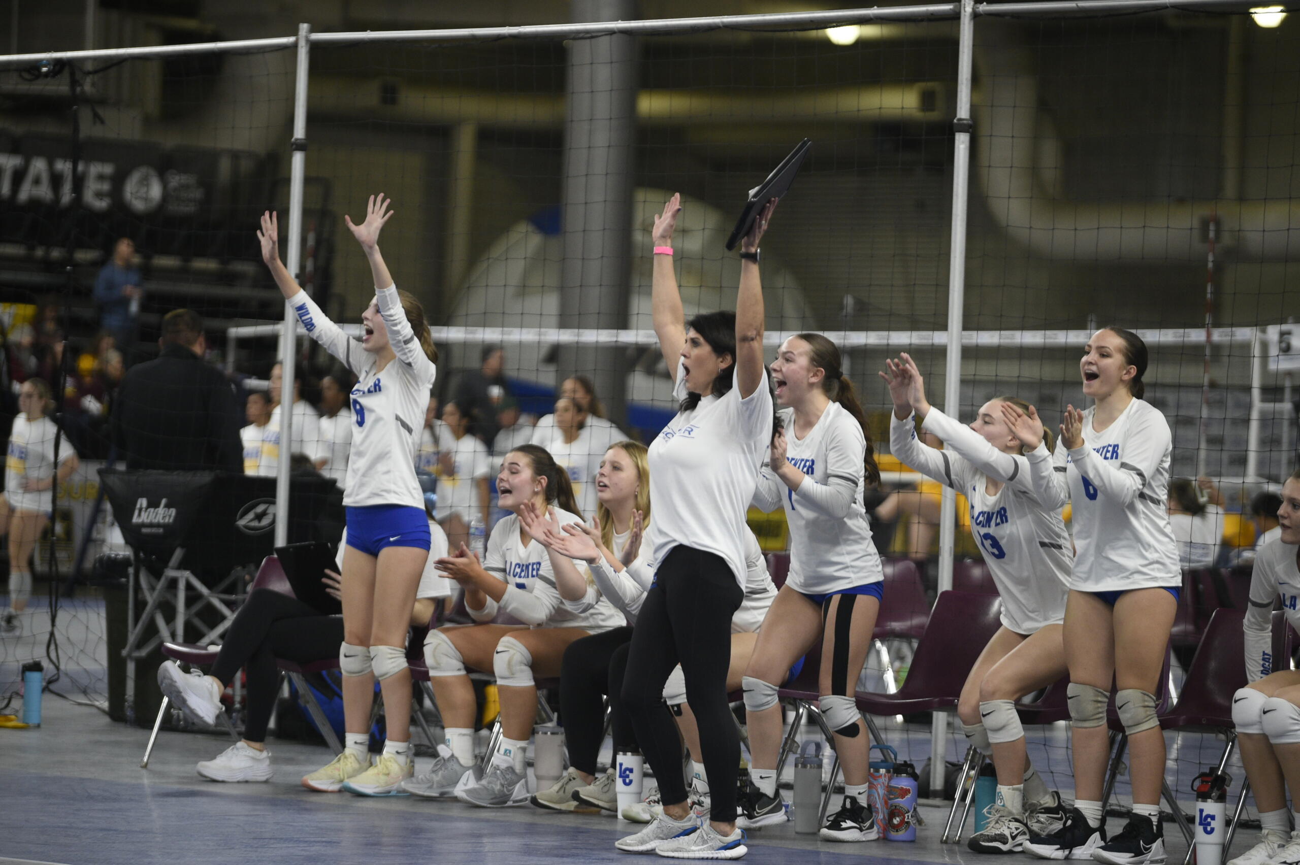 La Center head coach Cymany O'Brien, center, and the Wildcats bench celebrate a point in a Class 1A quarterfinal match against Cascade Christian on Friday, Nov. 11, 2023 at the Yakima Valley SunDome. La Center won in five sets to reach its first state semifinals since 1995.