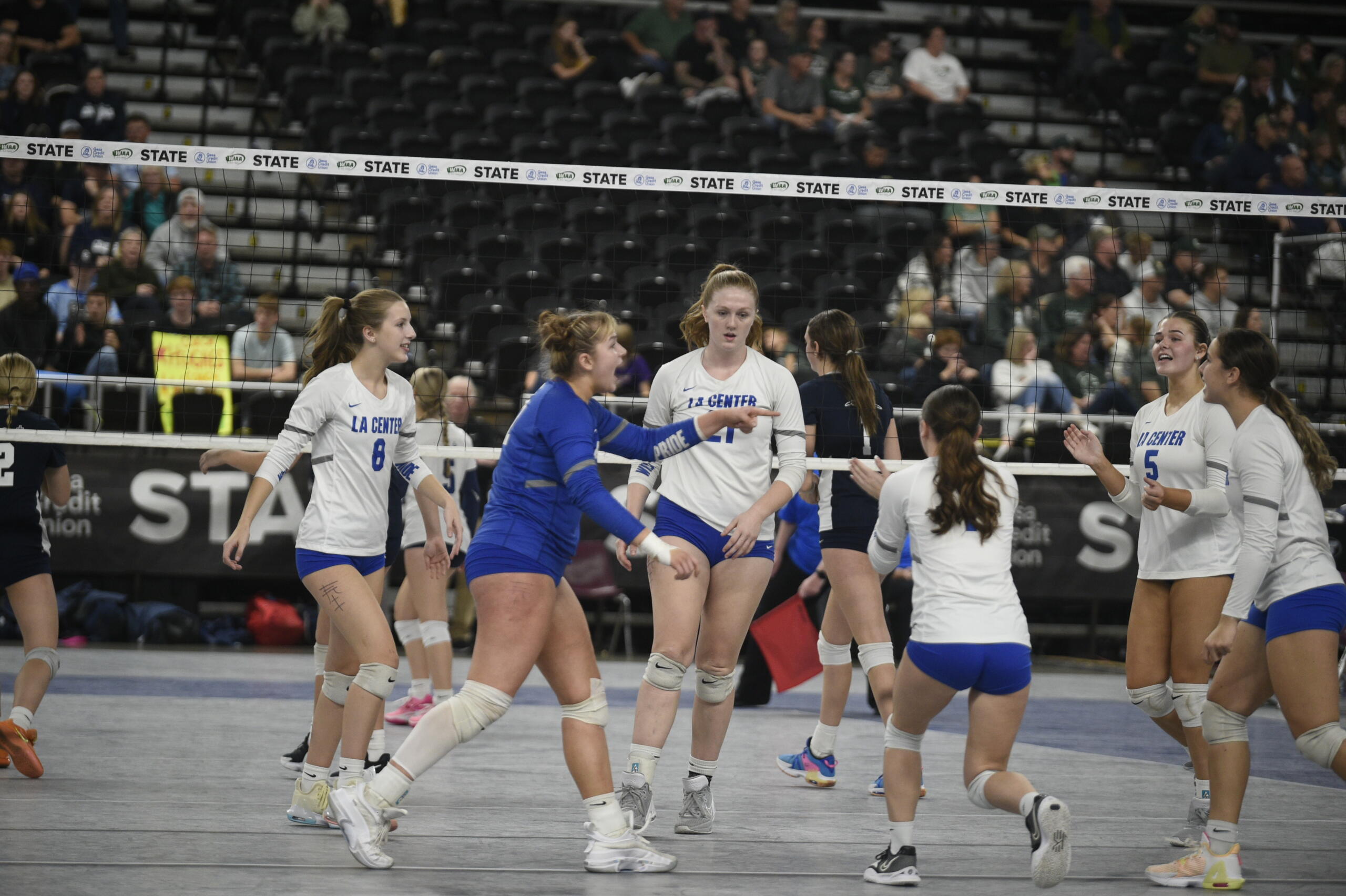 La Center libero Mia Achziger, in blue, and her Wildcats teammates celebrate a point in a Class 1A quarterfinal match against Cascade Christian on Friday, Nov. 11, 2023 at the Yakima Valley SunDome. La Center won in five sets to reach its first state semifinals since 1995.