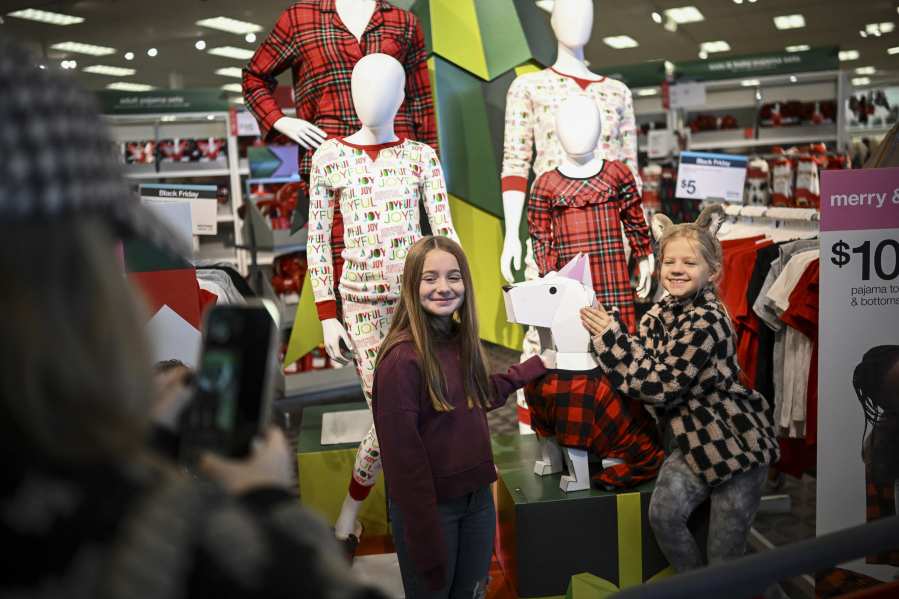 Nicole Leary of Edina, Minn., takes a photo of her daughter Sloane, 8, right, and niece Teagan Swanson, 9, as they pose with a mannequin of Target mascot &ldquo;Bullseye&rdquo; during Black Friday shopping Nov. 25, 2022, at Target in Edina.