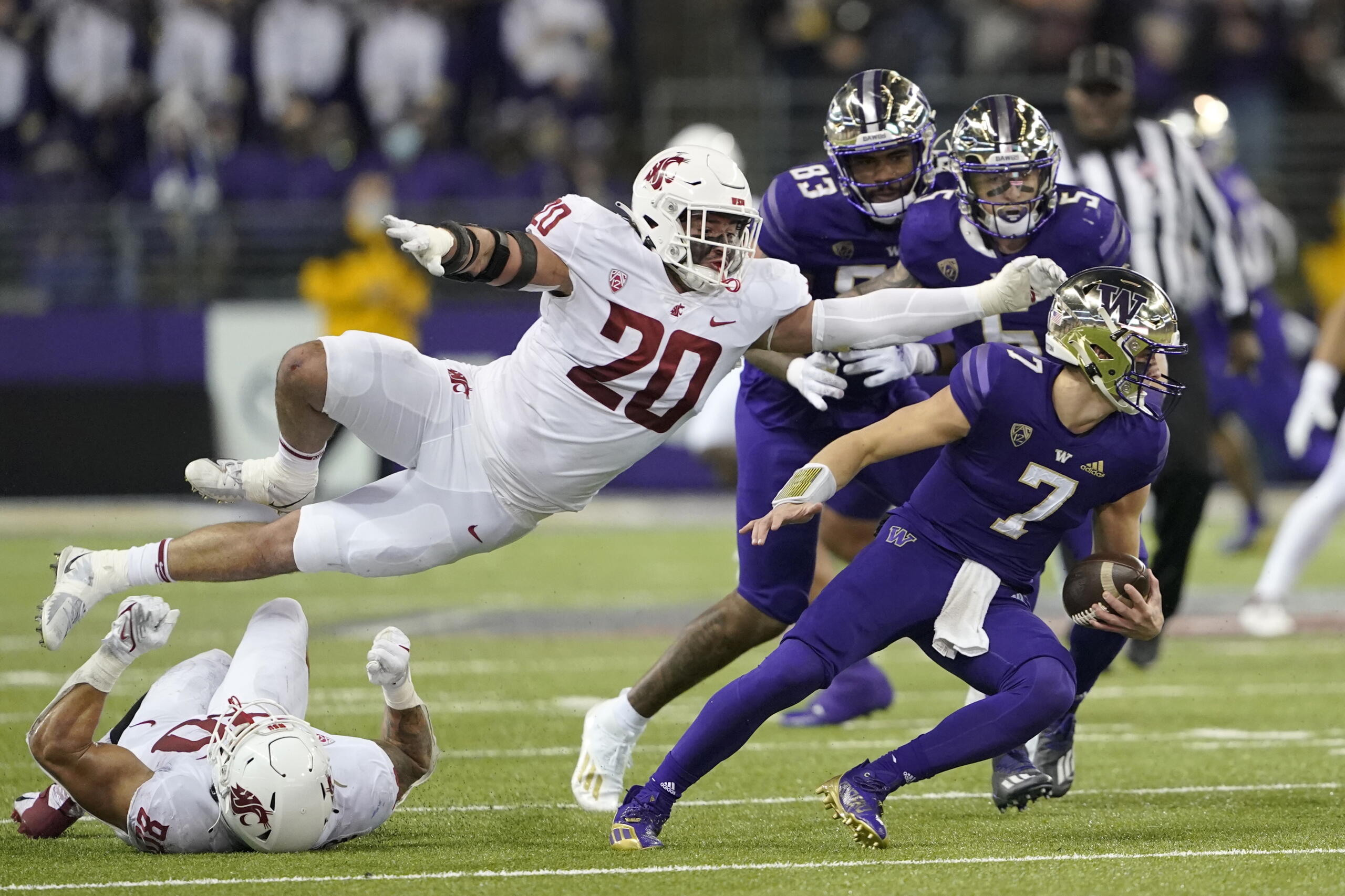 Washington State defensive end Quinn Roff (20) leaps in pursuit of Washington quarterback Sam Huard (7) during the second half of an NCAA college football game, Friday, Nov. 26, 2021, in Seattle. (AP Photo/Ted S.