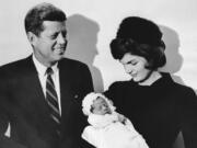 John F. Kennedy and his wife Jacqueline hold their son John during the christening ceremony Dec. 10, 1960, at the chapel of Georgetown University in Washington, D.C.