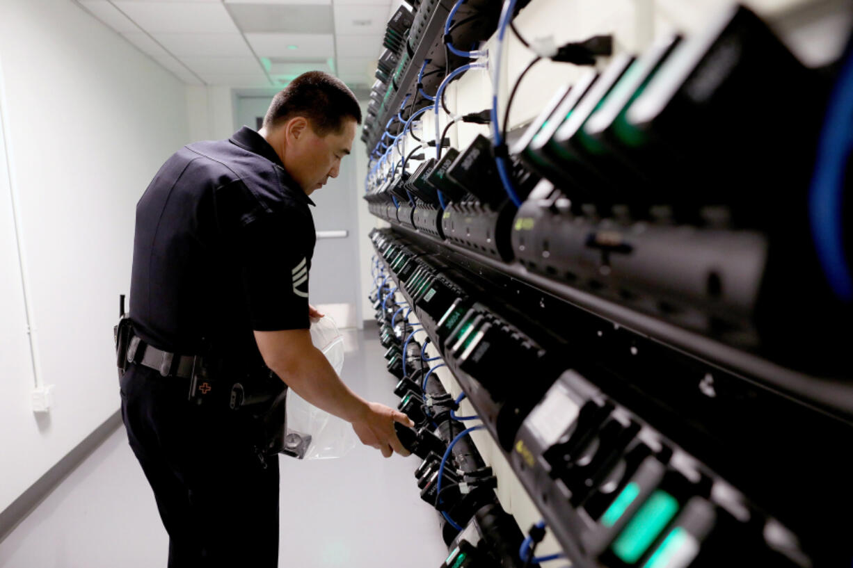 Los Angeles Police Department Metropolitan Division Sergeant Steve Wang loads officers body cameras in the docking stations to be downloaded at the end of the shift at the Metropolitan Division station in Los Angeles on March 16, 2019.