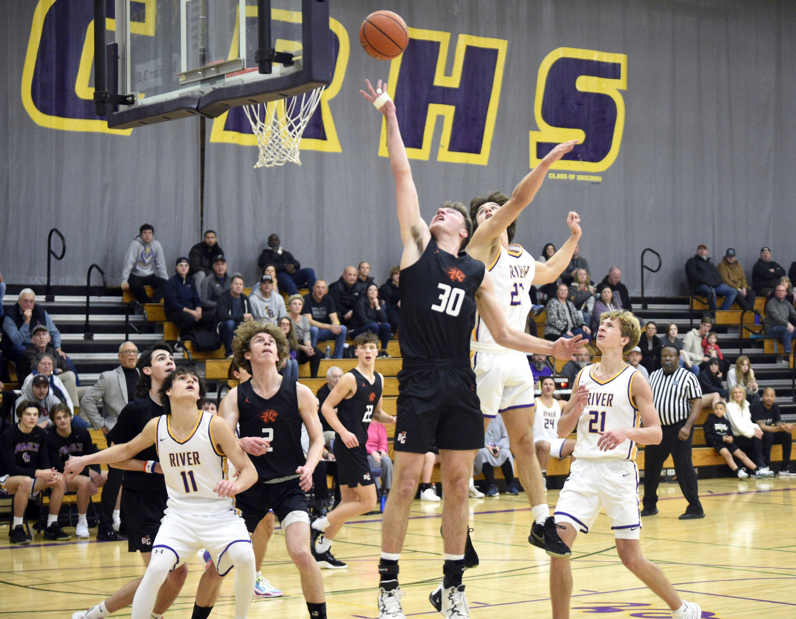 Battle Ground’s Austin Ralphs (30) flips a shot contested by Columbia River’s Aaron Hoey in a non-league boys basketball game on Tuesday, Nov. 28, 2023, at Columbia River High School.