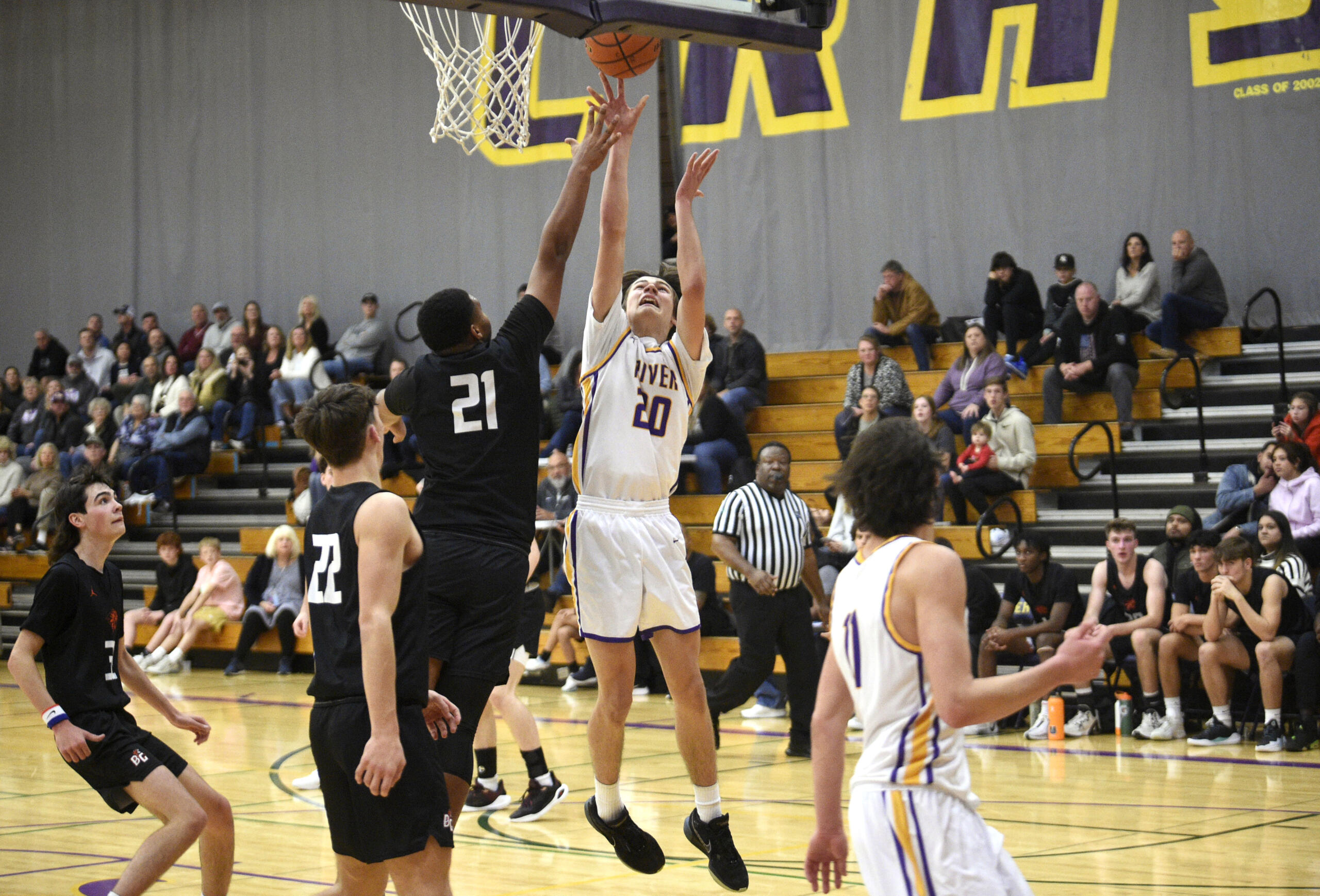 Columbia River’s Luca Phillips (20) goes up for a shot against Battle Ground’s James Gill (21) in a non-league boys basketball game on Tuesday, Nov. 28, 2023, at Columbia River High School.
