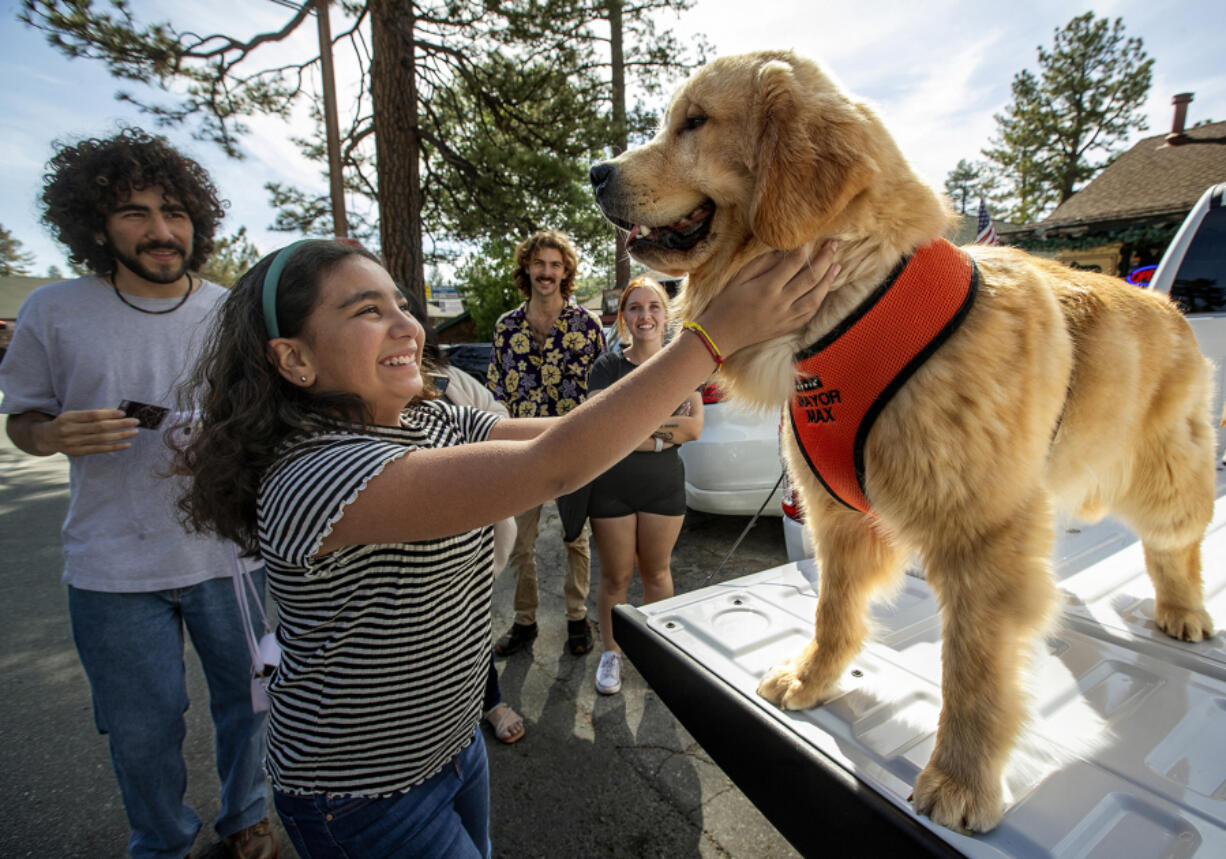 Naillah Benjell of Los Angeles greets Maximus Mighty-Dog Mueller III, otherwise known as Mayor Max III, the mayor of Idyllwild, during a public appearance.