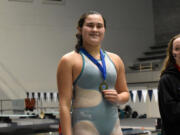 Rebecca Yamada of Ridgefield stands on the podium after receiving her medal for winning the 100-yard breaststroke at the Class 2A-1A state girls swimming championship at the King County Aquatic Center in Federal Way last month.