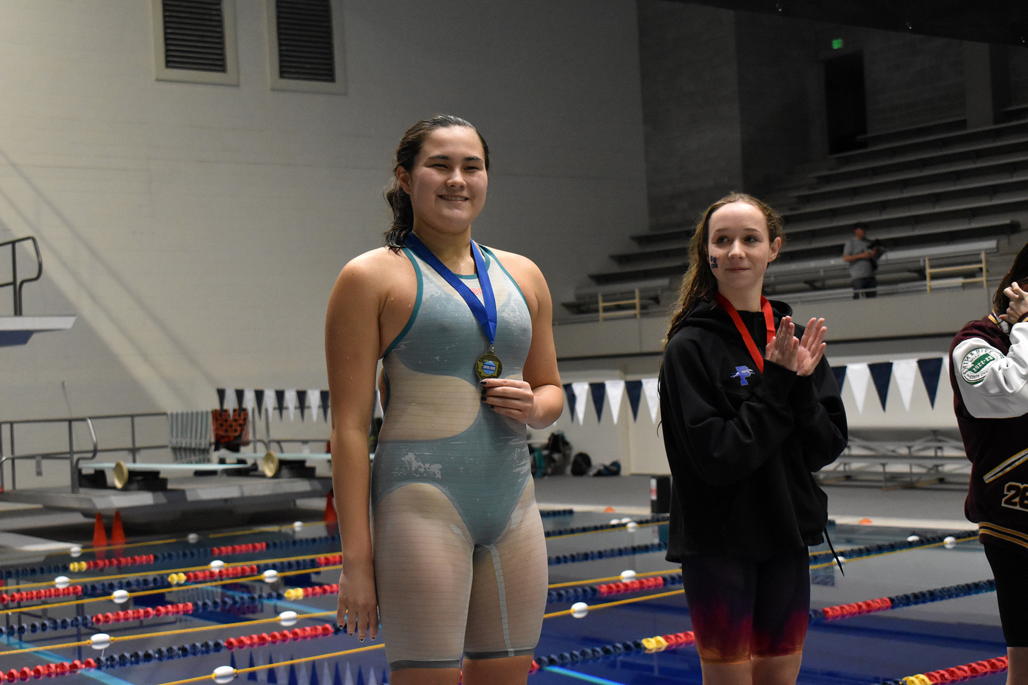 Rebecca Yamada of Ridgefield stands on the podium after receiving her medal for winning the 100-yard breaststroke at the Class 2A-1A state girls swimming championship at the King County Aquatic Center in Federal Way on Saturday, Nov. 11, 2023.