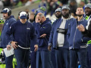 From left, Seattle Seahawks offensive coordinator Shane Waldron, far left, special teams coordinator Larry Izzo, strength and conditioning assistant Jamie Yanchar and offensive assistant Donovan Jackson, in grey and blue, look on from the sideline during the first half of an NFL football game against the San Francisco 49ers, Thursday, Nov. 23, 2023, in Seattle. The 49ers won 31-13.