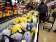 People shop for frozen turkeys for Thanksgiving dinner at a grocery store in 2021. (AP Photo/Nam Y.