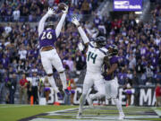 Baltimore Ravens safety Geno Stone (26) and cornerback Marlon Humphrey, right, break up a pass intended for Seattle Seahawks wide receiver DK Metcalf (14) during the second half of an NFL football game, Sunday, Nov. 5, 2023, in Baltimore.