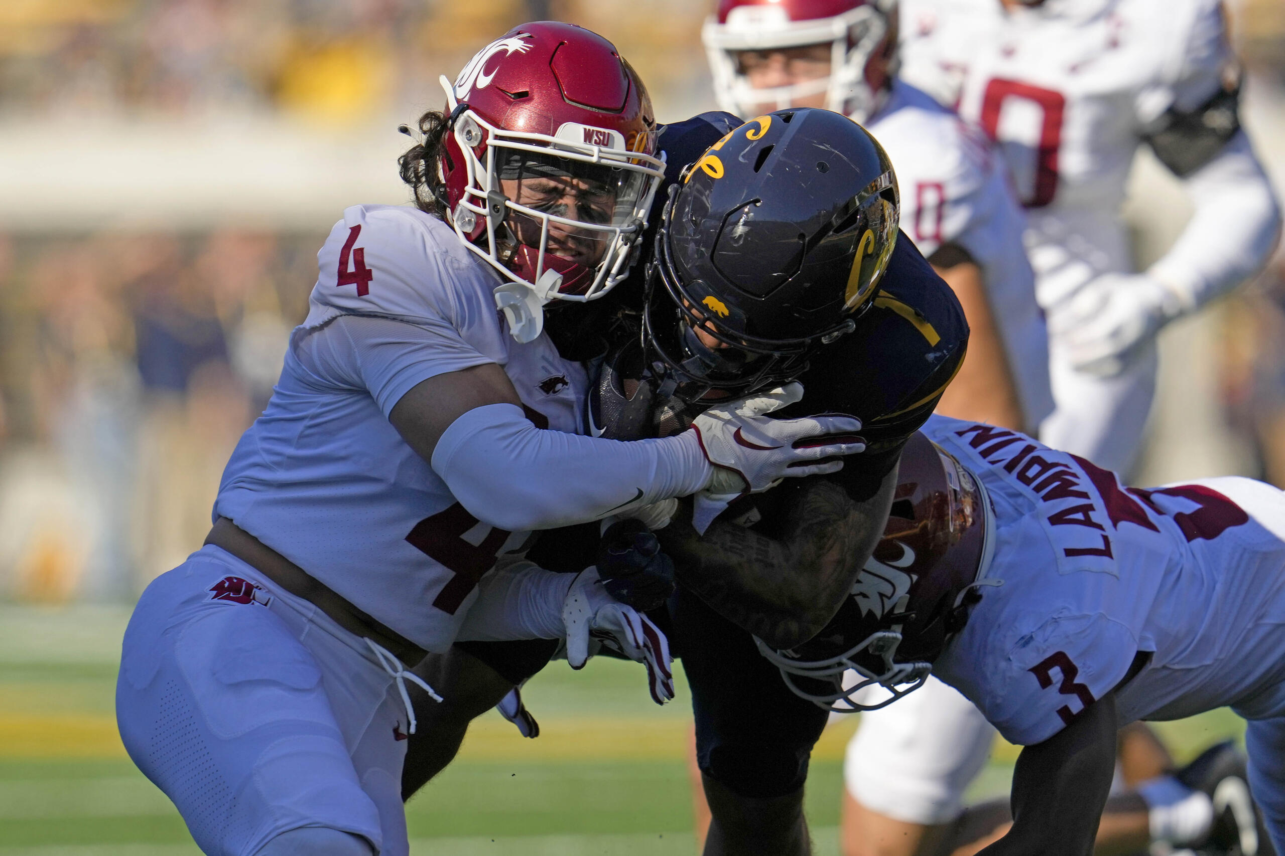 California running back Jaydn Ott, center, is tackled by Washington State defensive backs Kapena Gushiken, left, and Cam Lampkin during the first half of an NCAA college football game Saturday, Nov. 11, 2023, in Berkeley, Calif. (AP Photo/Godofredo A.