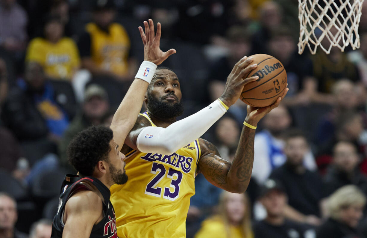 Los Angeles Lakers forward LeBron James shoots next to Portland Trail Blazers guard Skylar Mays during the first half of an NBA basketball In-Season Tournament game in Portland, Ore., Friday, Nov. 17, 2023.