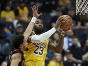 Los Angeles Lakers forward LeBron James shoots next to Portland Trail Blazers guard Skylar Mays during the first half of an NBA basketball In-Season Tournament game in Portland, Ore., Friday, Nov. 17, 2023.