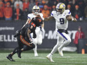 Washington quarterback Michael Penix Jr. (9) dodges Oregon State linebacker Easton Mascarenas-Arnold (5) during the first half of an NCAA college football game Saturday, Nov. 18, 2023, in Corvallis, Ore.